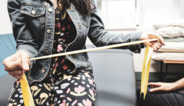 Woman using a yellow stretch band for her arms